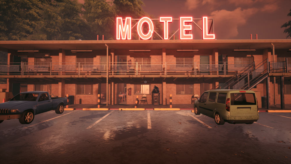 This image shows the outside of a motel from the parking lot. 